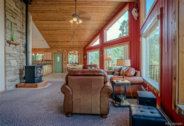 a living room with furniture a fireplace and a floor to ceiling window