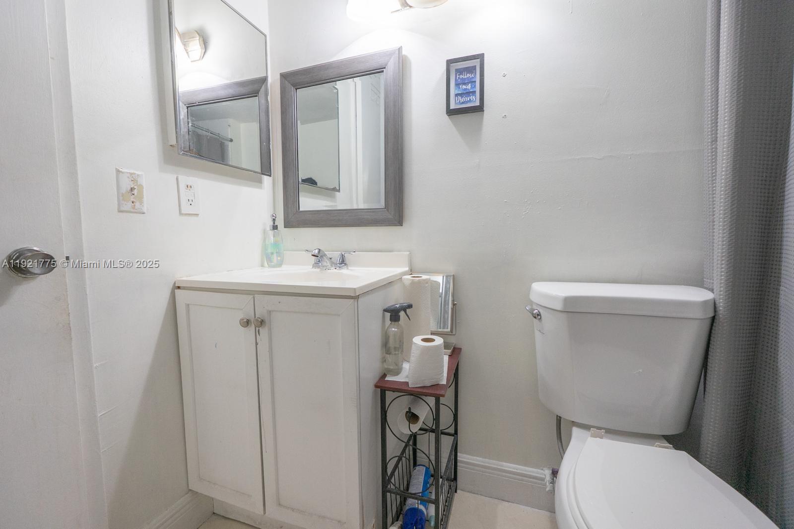 6276 Northwest 186th Street, Unit 112 Hialeah, FL 33015 - Photo 12 of 22 a bathroom with a toilet sink and mirror