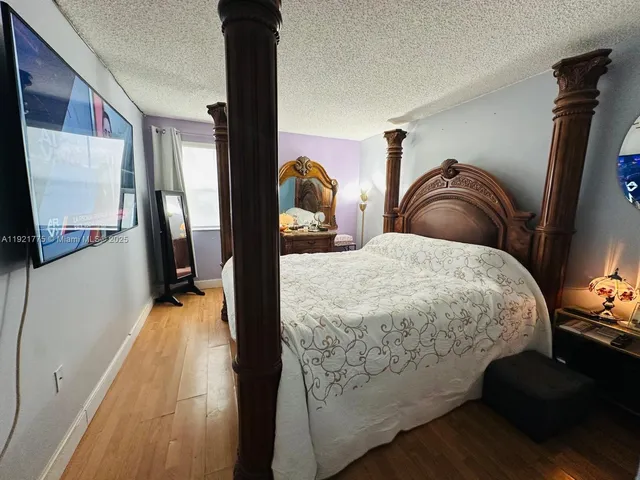 a bedroom with a bed and a flat tv screen on the dresser