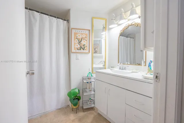 a bathroom with a sink a mirror and a shower curtain