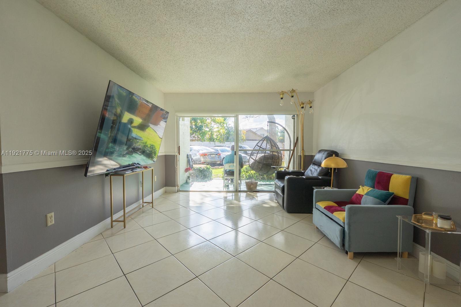 6276 Northwest 186th Street, Unit 112 Hialeah, FL 33015 - Photo 18 of 22 a living room with furniture and a flat screen tv