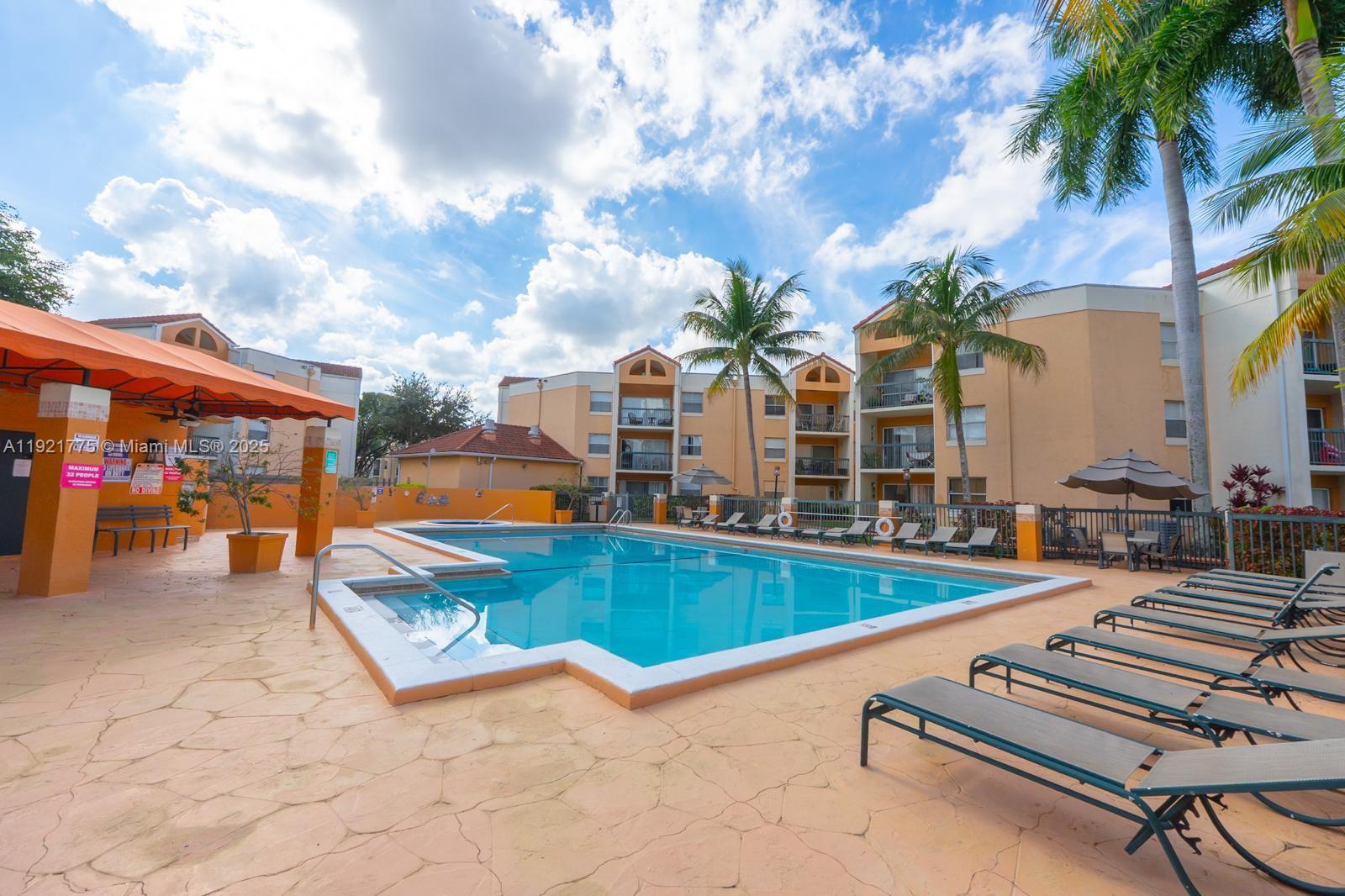 6276 Northwest 186th Street, Unit 112 Hialeah, FL 33015 - Photo 22 of 22 a view of a patio with swimming pool table and chairs