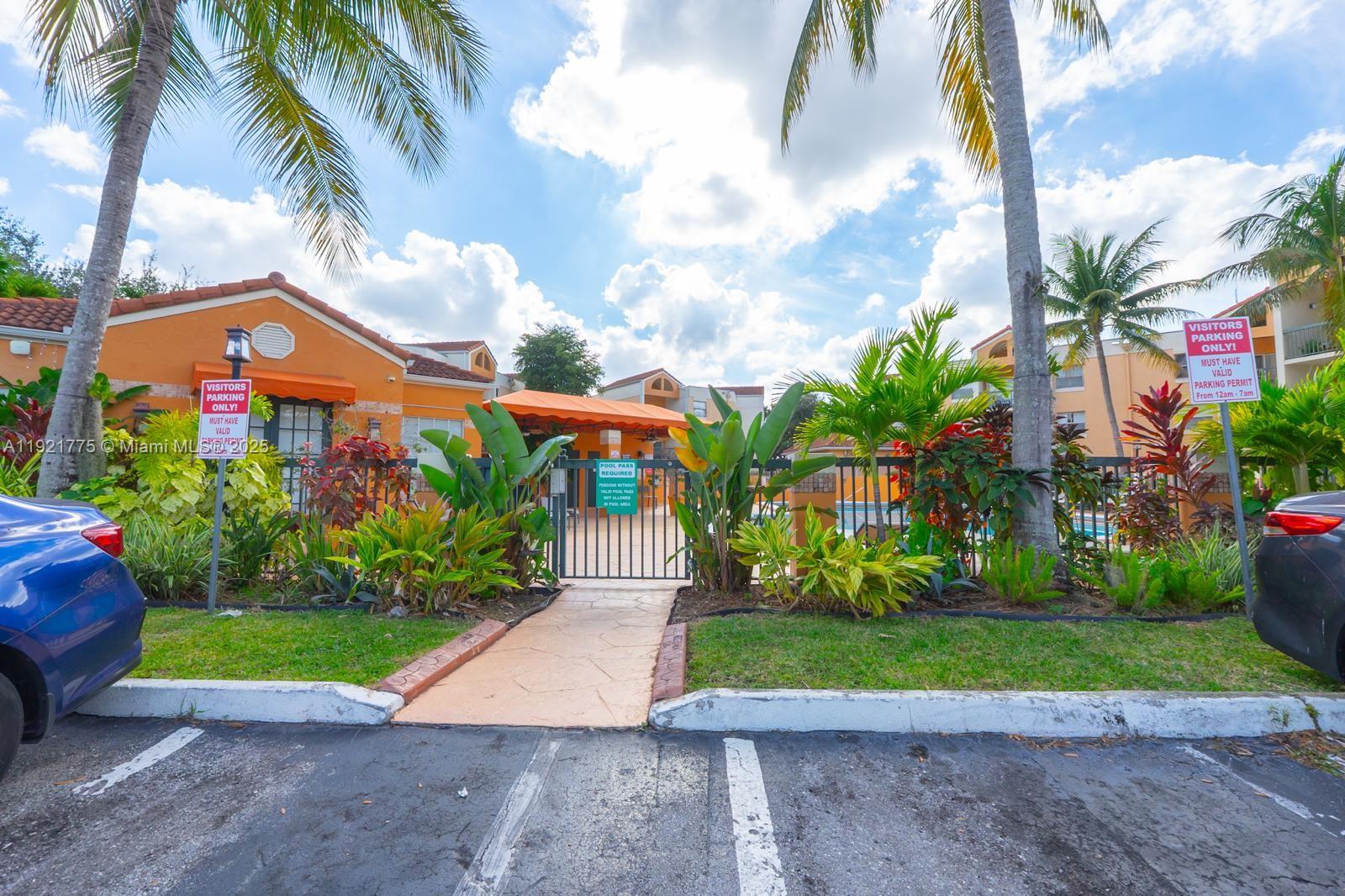 6276 Northwest 186th Street, Unit 112 Hialeah, FL 33015 - Photo 7 of 22 a front view of a house with a yard and potted plants