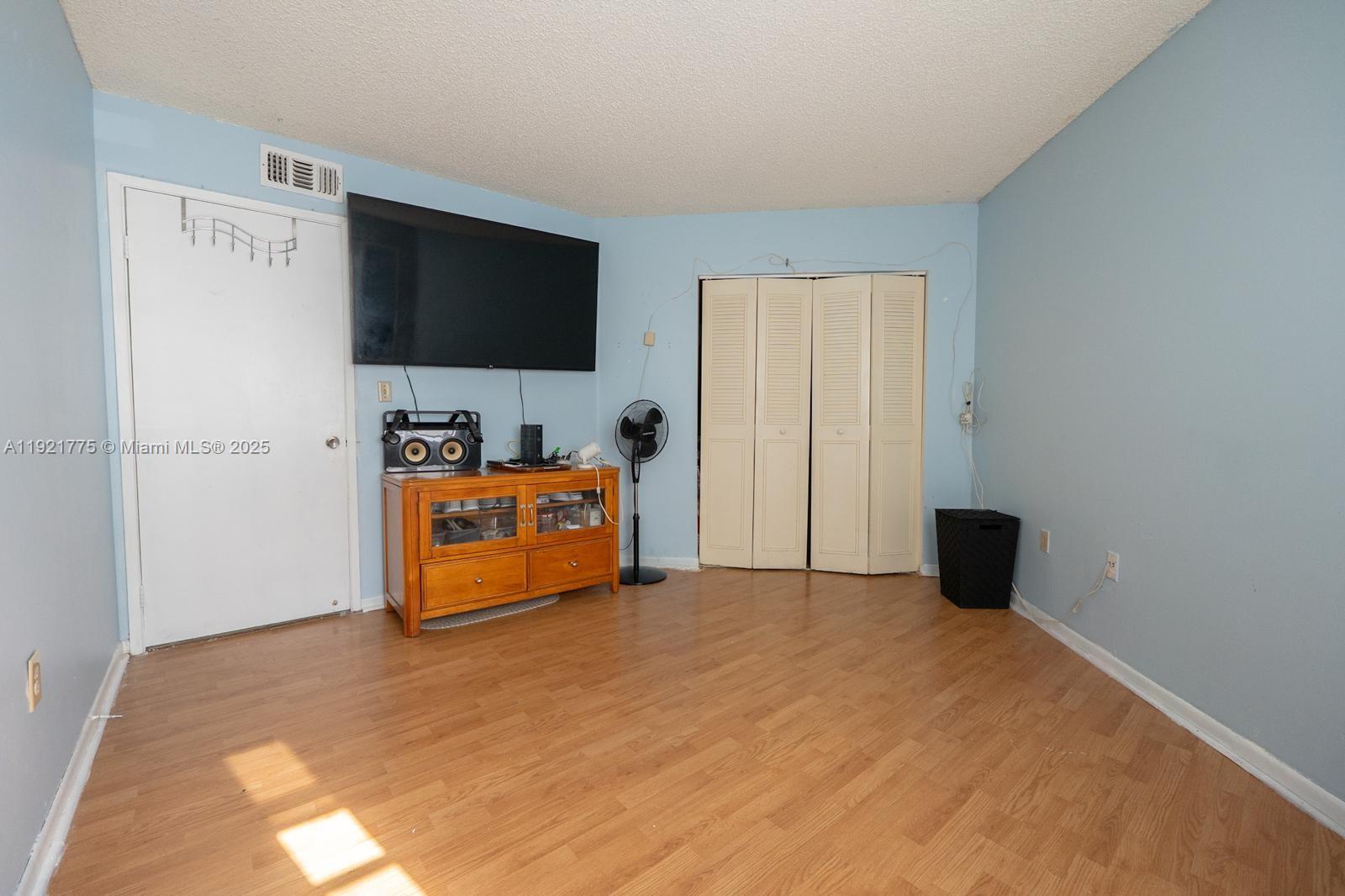 6276 Northwest 186th Street, Unit 112 Hialeah, FL 33015 - Photo 8 of 22 a bedroom with furniture and flat screen tv