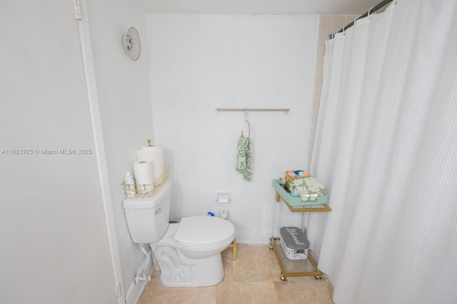 6276 Northwest 186th Street, Unit 112 Hialeah, FL 33015 - Photo 10 of 22 a white toilet sitting next to a shower curtain