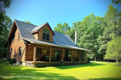 a view of a house with a yard potted plants and a large tree