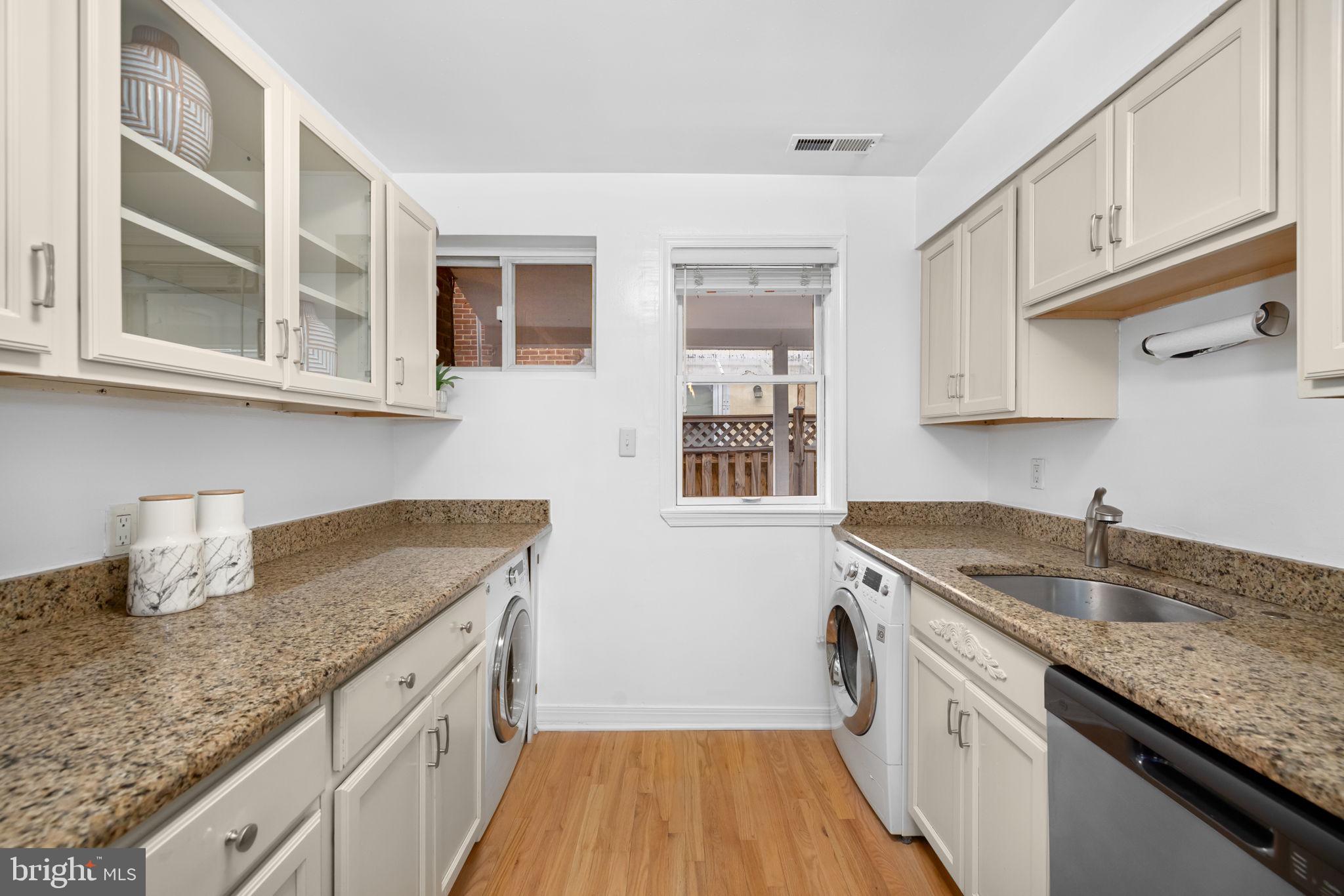 1615 45th Street Northwest Washington, DC 20007 - Photo 11 of 34 a kitchen with stainless steel appliances granite countertop a sink stove and cabinets