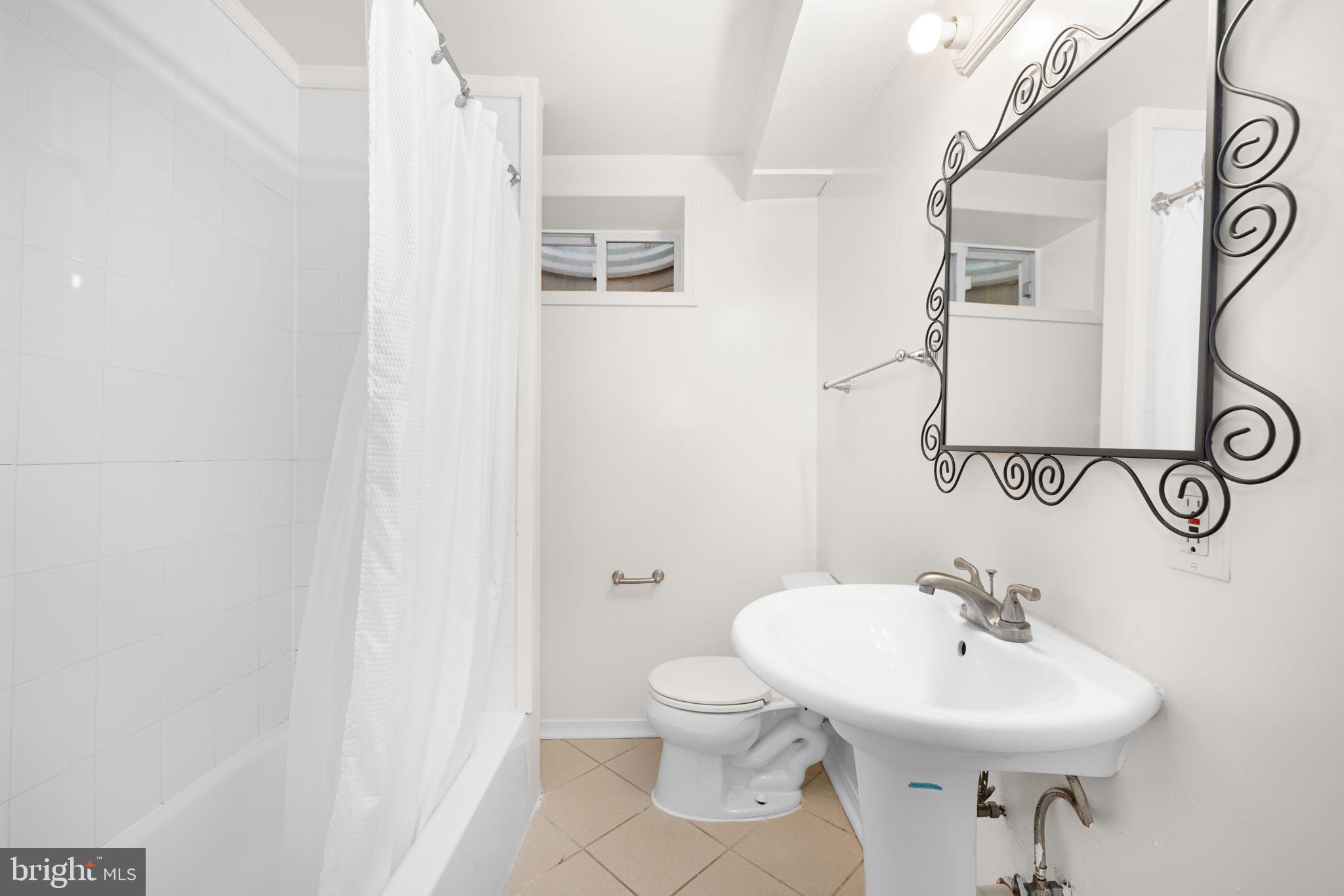1615 45th Street Northwest Washington, DC 20007 - Photo 28 of 34 a bathroom with a sink a toilet and a mirror