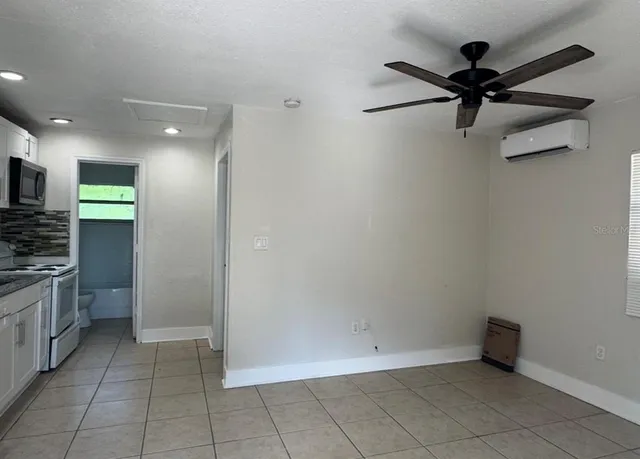 a view of a kitchen with a sink and dishwasher a refrigerator with white cabinets