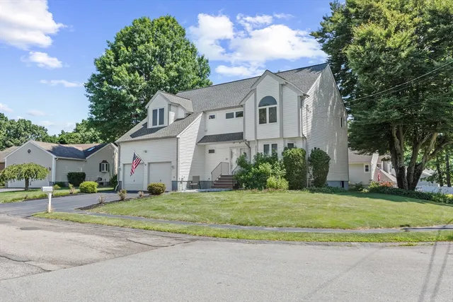 a white house that has a tree in front of it