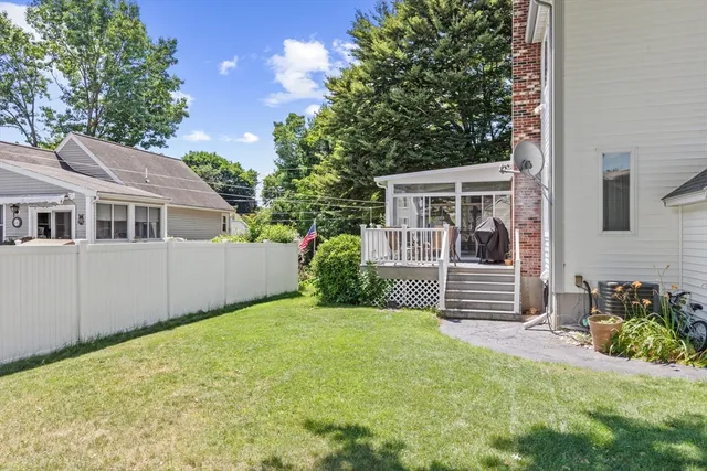 a view of a house with potted plants and a fence