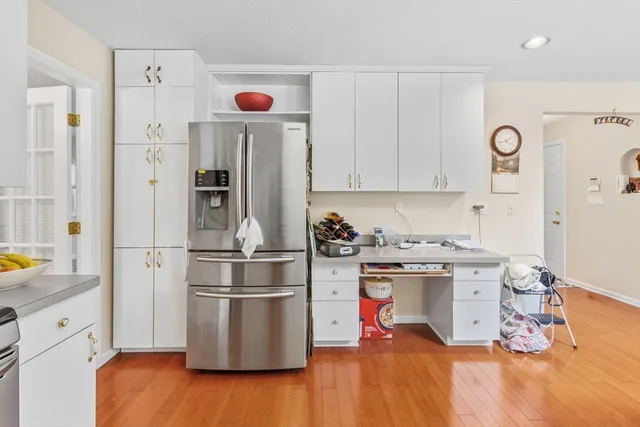 a kitchen with stainless steel appliances granite countertop a refrigerator stove and white cabinets