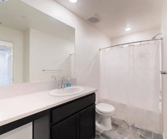 a bathroom with a sink a toilet a mirror and shower