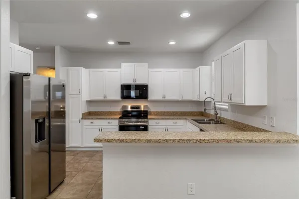 a kitchen with a refrigerator a stove a microwave and sink