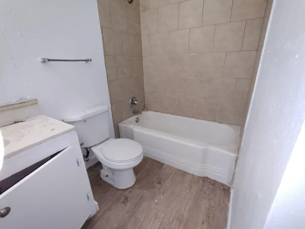 a white toilet sitting next to a bath tub