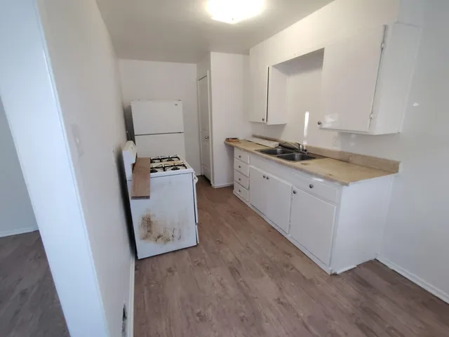 a kitchen with a sink a stove and cabinets