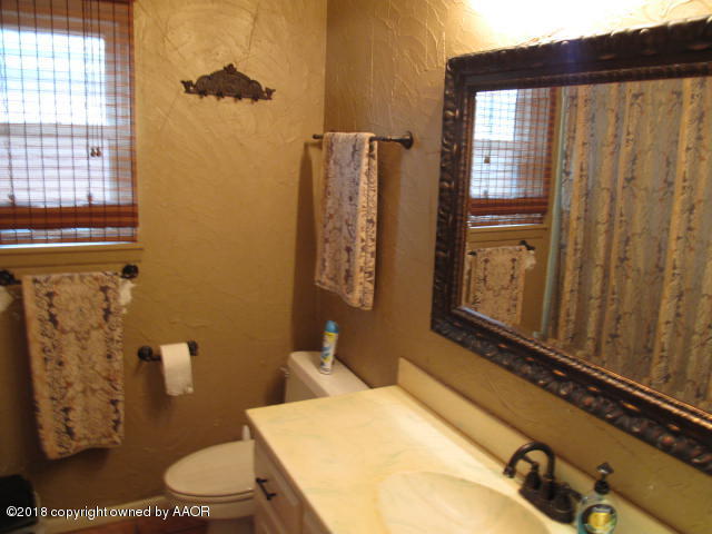 7201 Gainsborough Road Amarillo, TX 79106 - Photo 9 of 14 a bathroom with a sink mirror vanity and toilet
