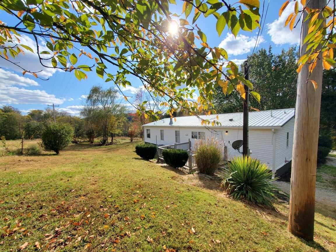 2990 Vanzant Bend Road Belvidere, TN 37306 - Photo 20 of 20 a backyard of a house with table and chairs under an umbrella
