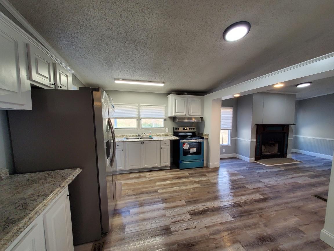 2990 Vanzant Bend Road Belvidere, TN 37306 - Photo 8 of 20 a kitchen with a refrigerator and a fireplace