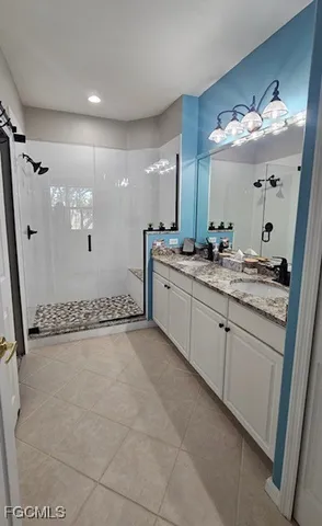 a bathroom with a sink mirror and a shower