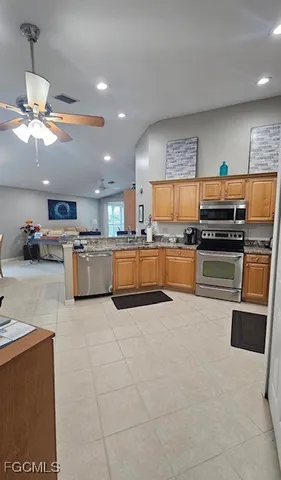 a large kitchen with stainless steel appliances granite countertop a stove and a refrigerator