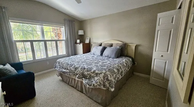 a bedroom with a bed and a couch next to a window