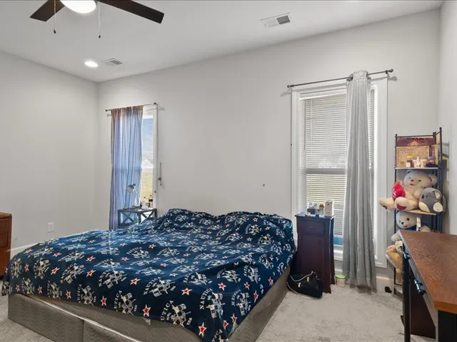 a bedroom with a bed dresser and a chandelier