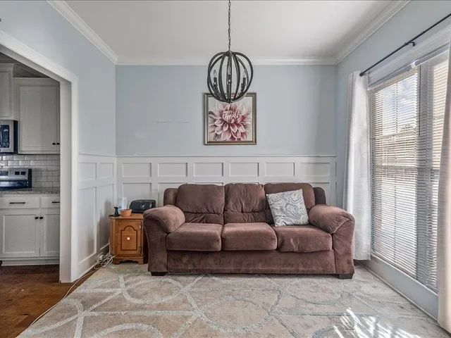 a living room with furniture a window and a lamp