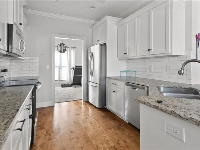 a kitchen with stainless steel appliances granite countertop a sink stove and refrigerator