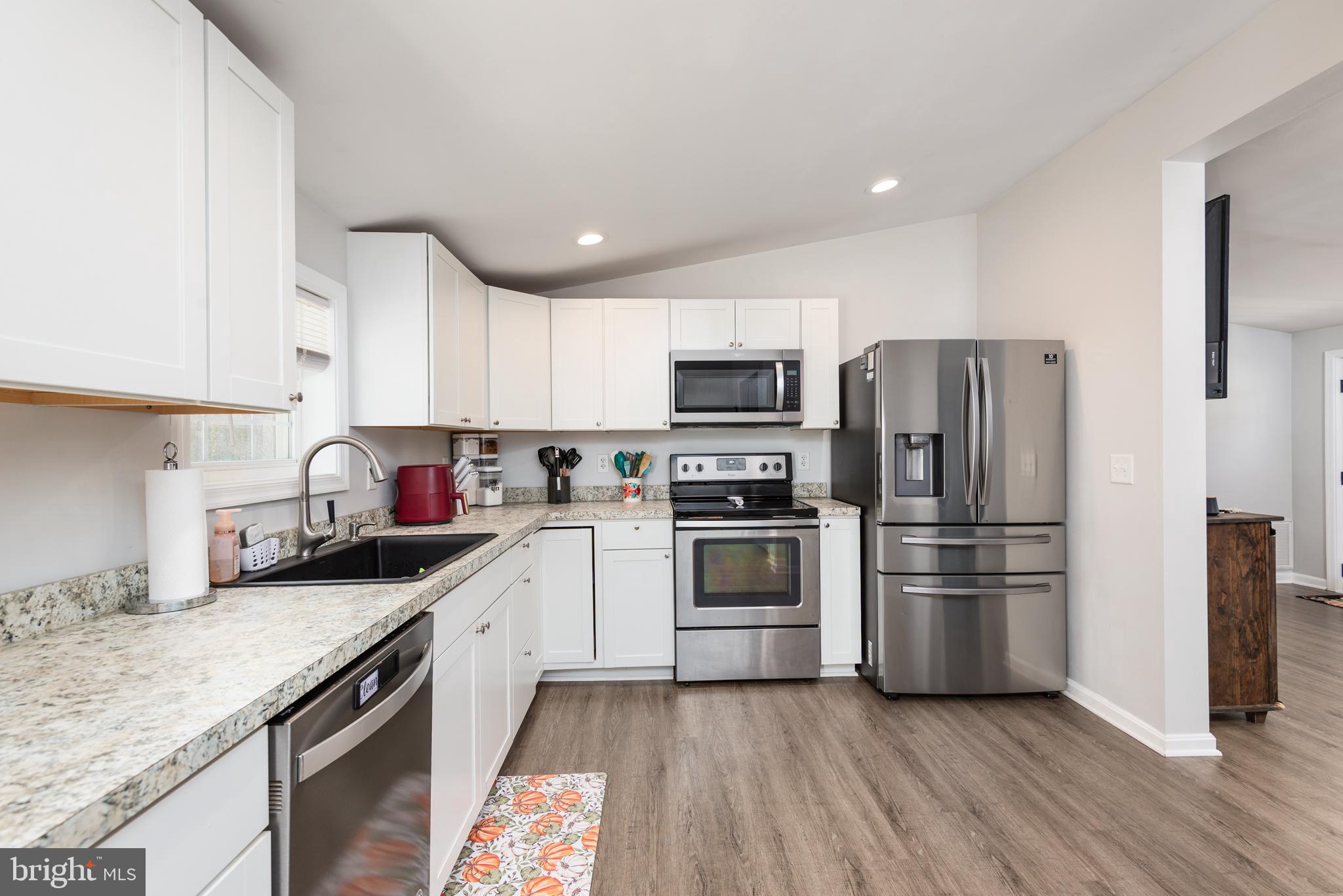 25607 Garey Road Denton, MD 21629 - Photo 9 of 19 a kitchen with granite countertop white cabinets and stainless steel appliances