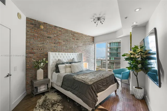 a bedroom with a large bed and a potted plant