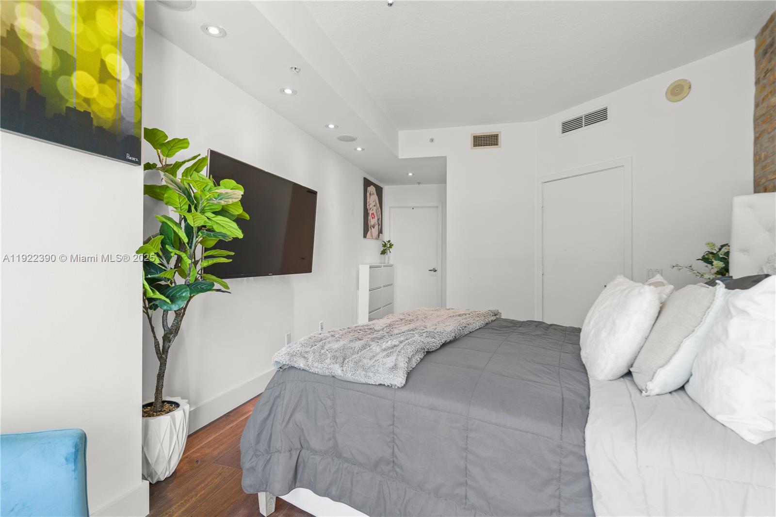 60 Southwest 13th Street, Unit 4616 Miami, FL 33130 - Photo 22 of 55 a bedroom with a bed and a potted plant