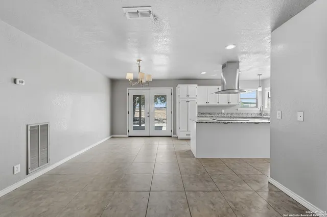 a view of a kitchen with kitchen island and stainless steel appliances