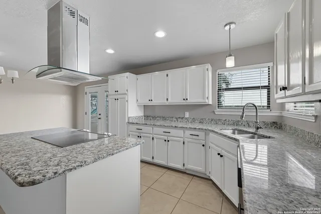 a kitchen with stainless steel appliances granite countertop a sink stove and cabinets