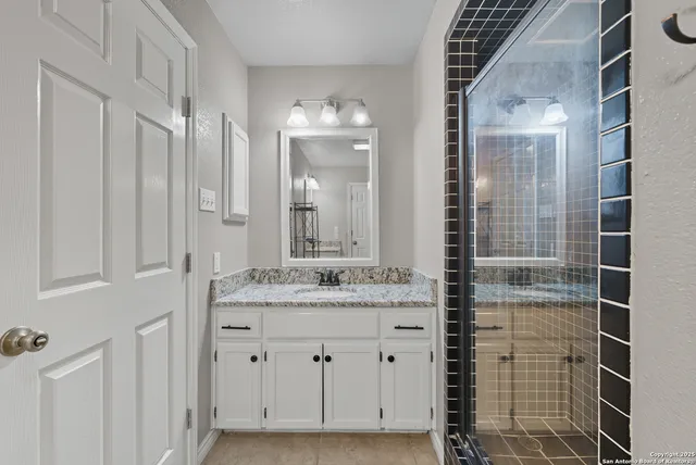 a bathroom with a granite countertop sink and a mirror