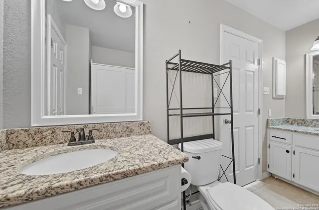 a bathroom with a granite countertop sink and a mirror