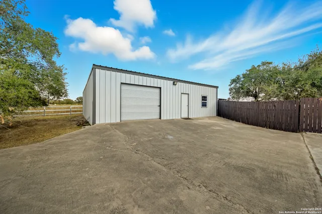 a view of garage with wooden fence