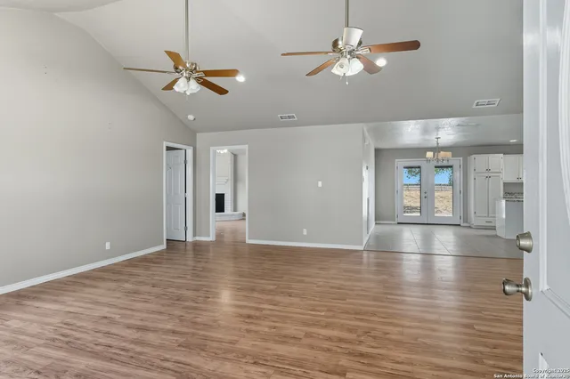 a view of an empty room with window and wooden floor