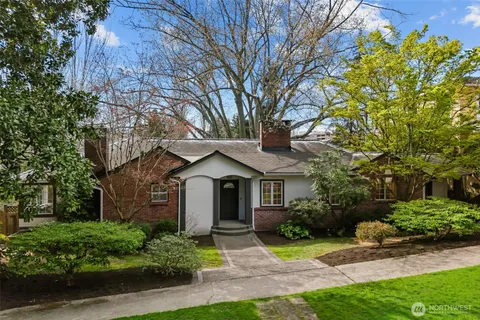 a front view of a house with a yard and potted plants
