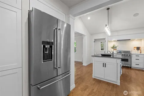 a kitchen with granite countertop a refrigerator and a sink