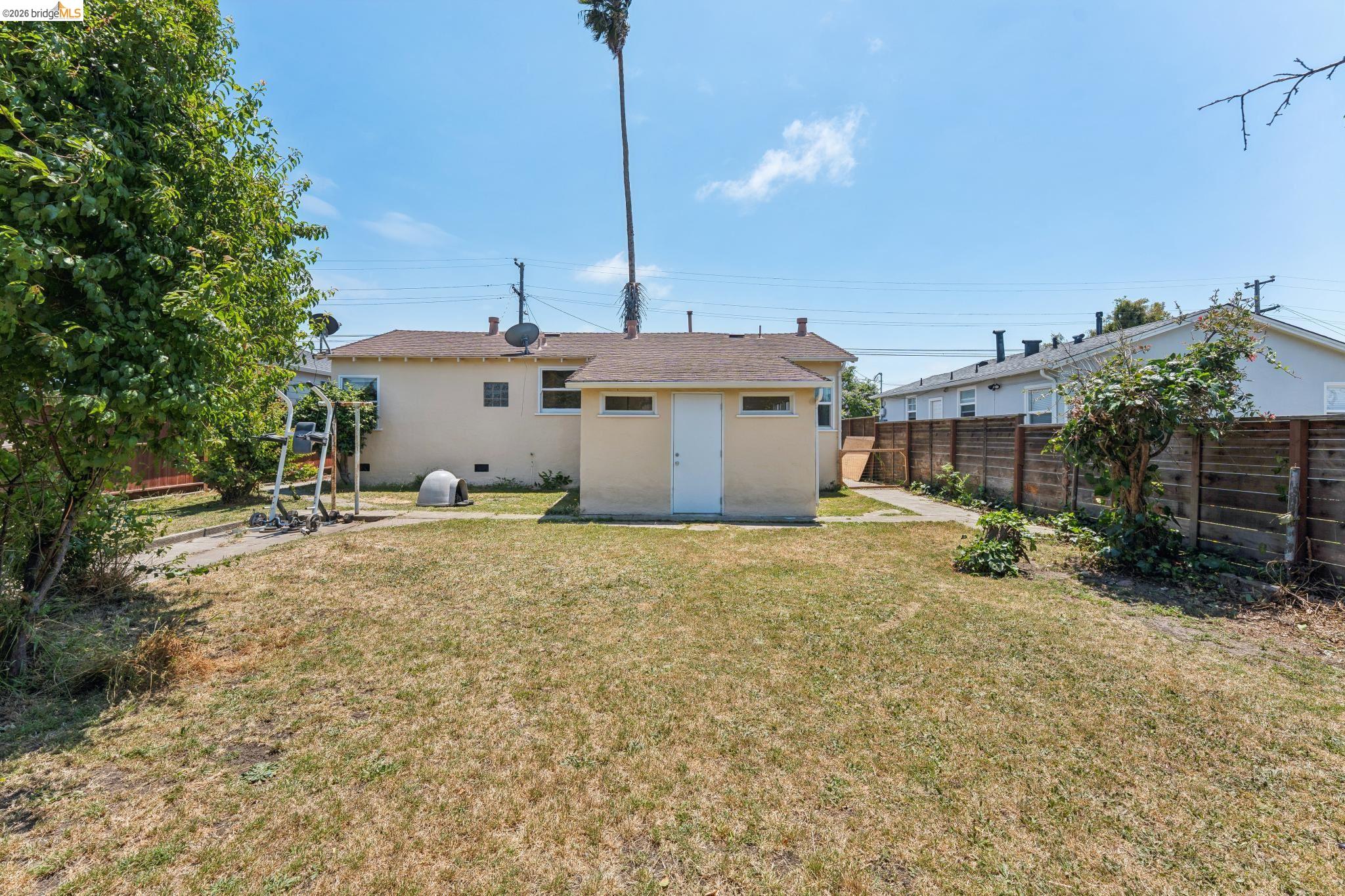 2879 Rheem Avenue Richmond, CA 94804 - Photo 37 of 45 Expansive backyard with a manicured lawn, concrete patio areas, and perimeter fencing