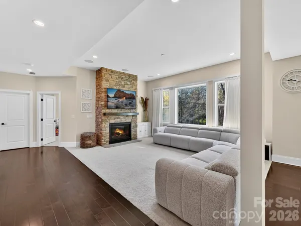 a large kitchen with white cabinets and wooden floor