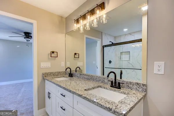a bathroom with a granite countertop sink a toilet and a mirror