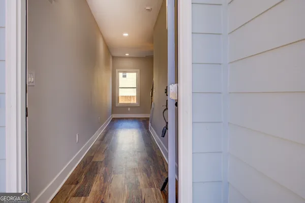 a view of a hallway with wooden floor and staircase