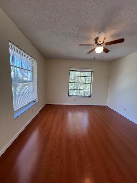 6800 Northeast 22nd Way, Unit 2132 Fort Lauderdale, FL 33308 - Photo 11 of 26 an empty room with wooden floor chandelier fan and windows
