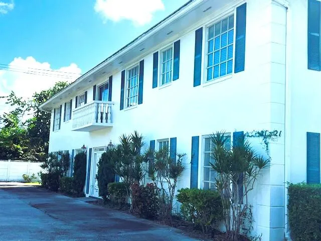 a front view of a house with a yard and potted plants
