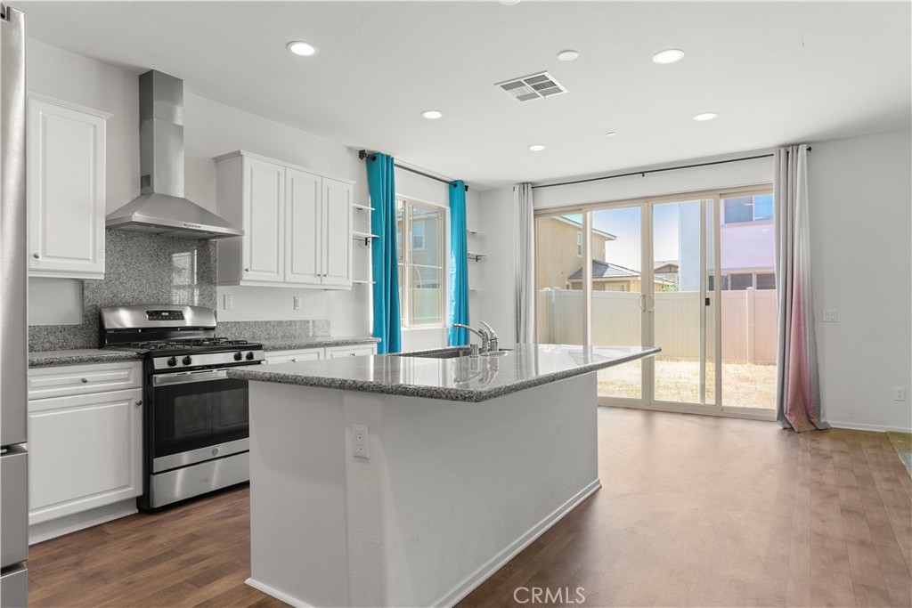 3320 Jack Rabbit Court Perris, CA 92570 - Photo 11 of 42 a kitchen with stainless steel appliances granite countertop a stove and a refrigerator