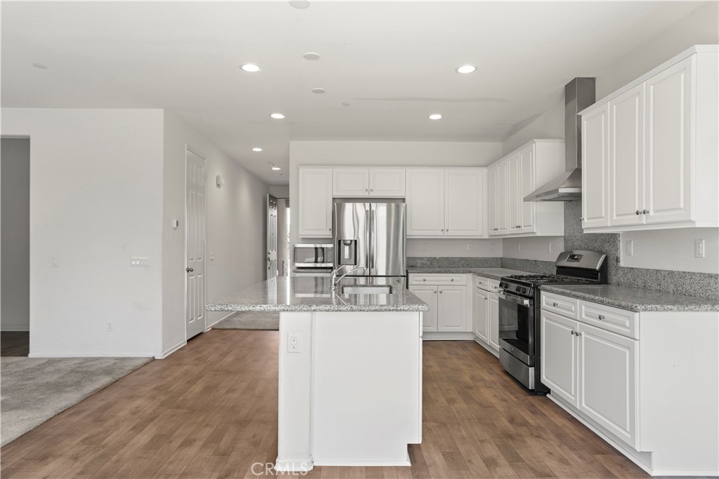 3320 Jack Rabbit Court Perris, CA 92570 - Photo 19 of 42 a large kitchen with kitchen island a sink stainless steel appliances and cabinets