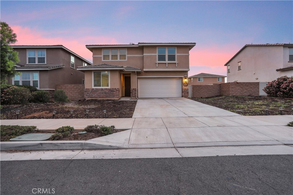 3320 Jack Rabbit Court Perris, CA 92570 - Photo 2 of 42 a front view of a house with a yard and garage