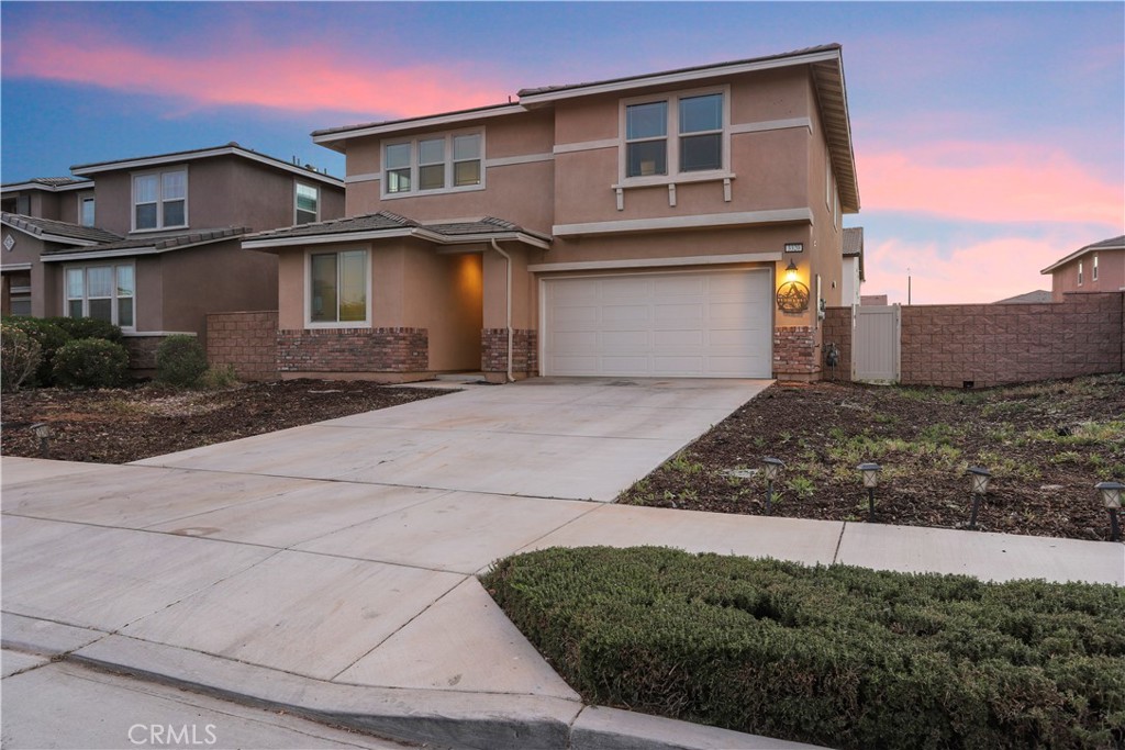 3320 Jack Rabbit Court Perris, CA 92570 - Photo 3 of 42 a front view of a house with a yard and garage
